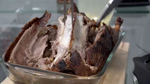 Close-up of a roast duck that a man cuts with a large kitchen knife on a plate Video stock 125393829