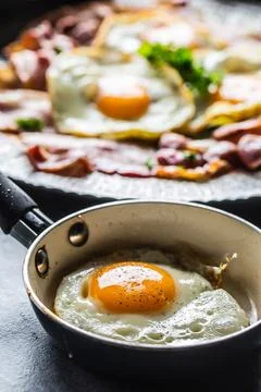 Close-up roasted bacon and egg with herbs. Stock Photos