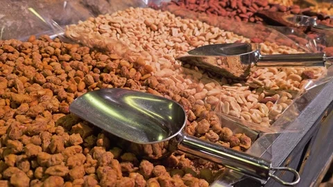 Close-up of roasted cashews in a bulk nut display, with shiny metal scoop Stock Footage 339848498