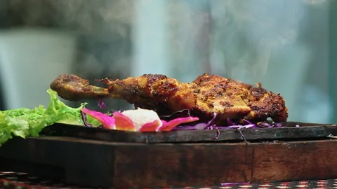 Close-Up Roasted Chicken BBQ Leg Piece on round table with Smoke Stock Footage 200954069