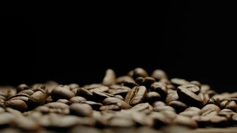 Close-up of roasted coffee beans against a black background in rotation. 스톡 동영상 295775359