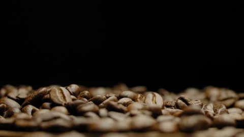 Close-up of roasted coffee beans against a black background in rotation. Stock Footage 295775933
