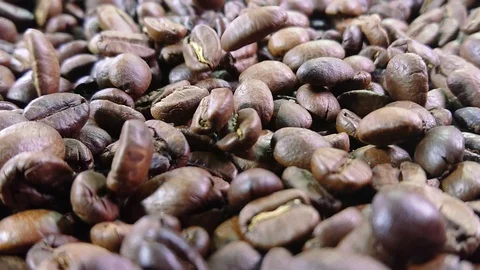 Close-up of roasted coffee beans are falling and spinning in slow motion Stock Footage 127651988
