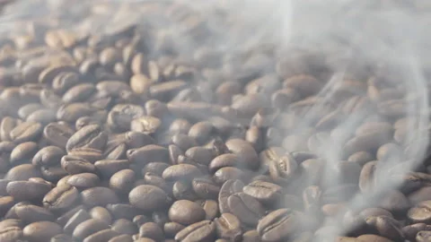 Close-up of roasted coffee beans. Aromatic coffee beans are roasted smoke coming Stock Footage 195122808