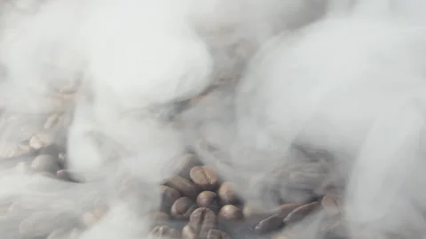 Close-up of roasted coffee beans. Aromatic coffee beans are roasted smoke coming Stock Footage 196010073