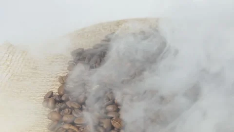 Close-up of roasted coffee beans. Aromatic coffee beans are roasted smoke coming Stock Footage 196187597