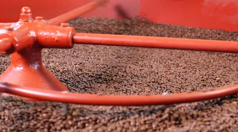 Close up roasted coffee beans being turned &amp; stirred in industrial machine Stock Footage 52314037