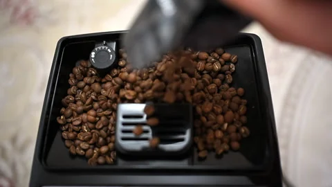 Close up of roasted coffee beans being poured into a coffee grinder Stock Footage 329389927