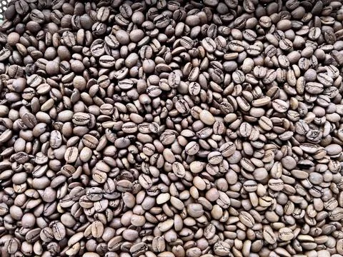 Close up of roasted coffee beans create a rich, organic background or texture. Stock Photos
