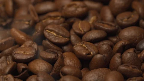 Close up of roasted coffee beans rotating with smoke. Vídeos de archivo 128338143