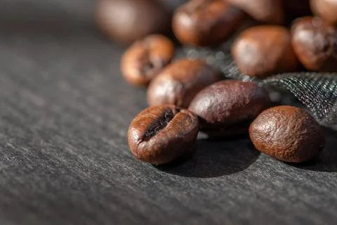 Close Up Of Roasted Coffee Beans Scattered On Dark Surface Fotos de archivo