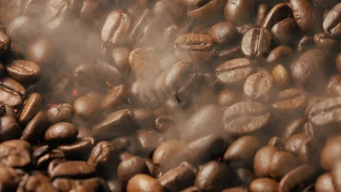 Close-up of roasted coffee beans. Smoke rises from the coffee beans Stock Footage 263340288