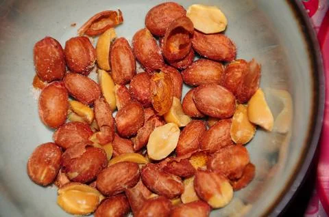 Close-up of roasted peanuts in a bowl, showcasing their texture and color Stock Photos