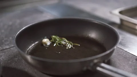 Close up of roasting fragrant garlic and rosemary before cooking meat Stock-Footage 150418420