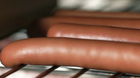 Close up of roasting Hot Dog on grill in the oven. French dog. Cooking hotdog Stock Footage 128309378
