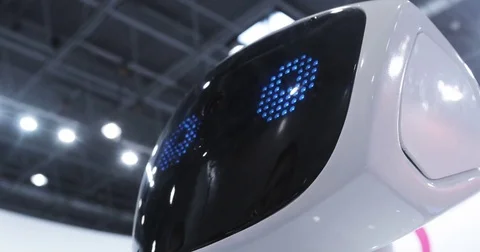 Close up of robot head. Robot emotions. The robot looks at the camera at the Stock Footage 76939907