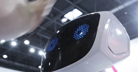 Close up of robot head. Robot emotions. The robot looks at the camera at the Stock Footage 76940061