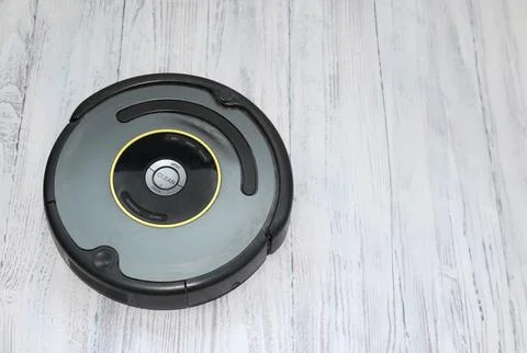 Close-up A robot vacuum cleaner effectively cleans a dirty floor. Top view Stock Photos