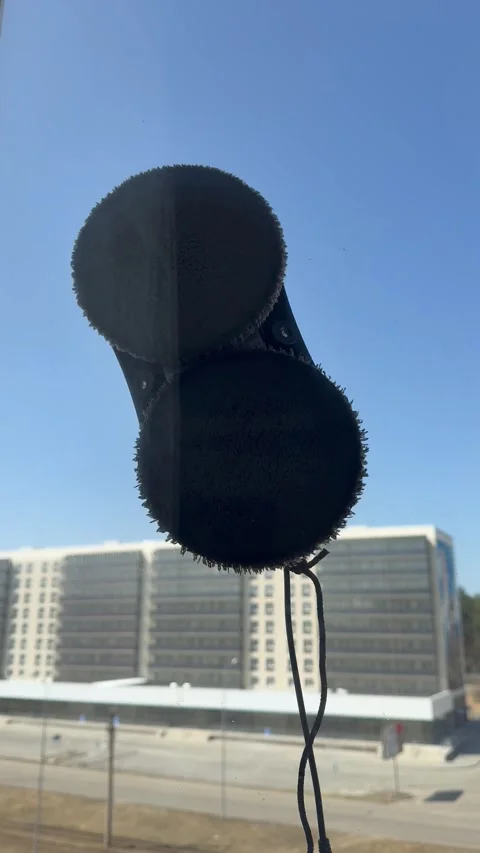 Close-up of robot window cleaner on street side of window against on blue sky Stock Footage 306574406