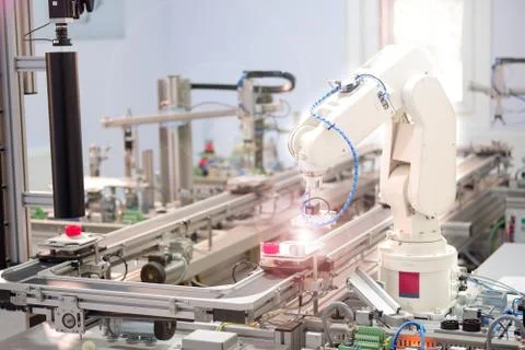 Close-up robotic arm. Engineer is working on laptop to programming smart fact Stock Photos