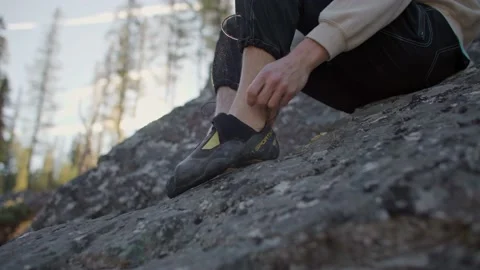 Close up of rock climber puts on rock climbing shoes 库存影片 220305964