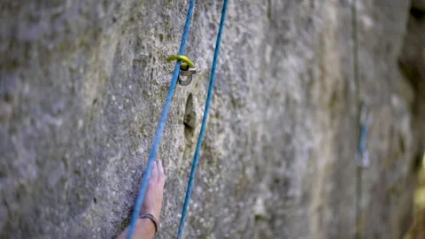 Close-up of rock climber reaching and gripping hold during climb 動画素材 131837511