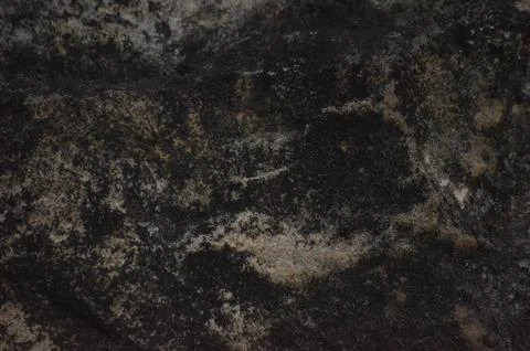 A close up of a rock with a dark, dirty surface. Stock Photos