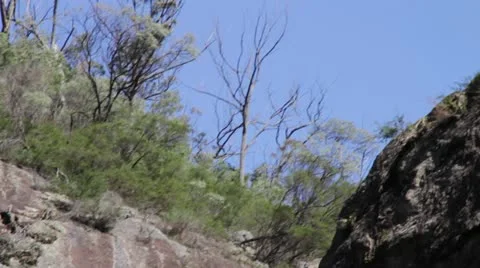 Close up of rock formations while tilting down by raging waterfall, Australia Stock Footage 11235019