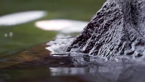 Close up of a rock in the wavy water Stock Footage 104257706