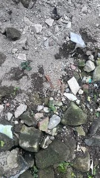 A close up of a rocky dirt surface with various stones, rubble, and a few sma Stock Photos