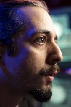 Close up of rogue technician looking at screen, using AI to evade security Foto stock