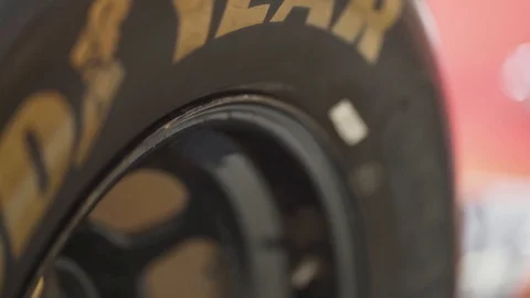 Close-up roll down shot of a racing car tire - Nascar / Stock car style. Stock Footage 107638914