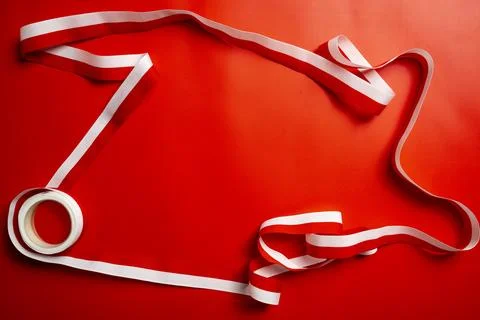 A close-up of a roll of red and white striped ribbon elegantly unwound and .. Stock Photos