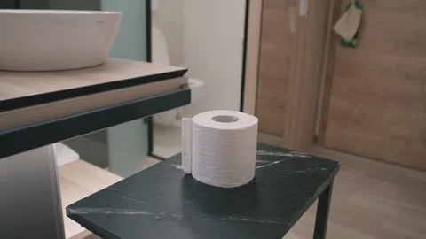 Close-up of a roll of toilet paper placed on a table in a modern bathroom with a Stock Footage 340458613