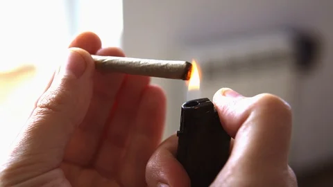 Close-up  rolled marijuana cigarette in the fire Stock Footage 106675096