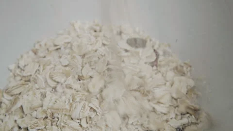 Close up of rolled oats and dried fruit being poured into for breakfast cereal Stock Footage 340406769