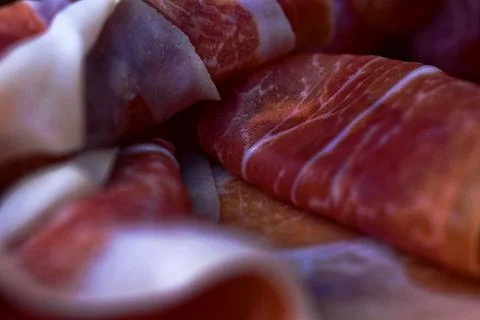 Close-up of rolled prosciutto ham. Shallow depth of field. Wine snacks. Stock Photos
