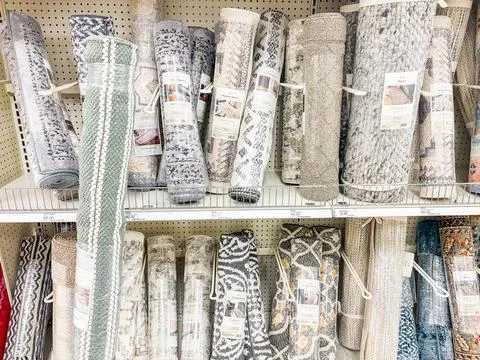 Close-up of rolled rugs with different patterns and textures on shelves in .. Stock Photos