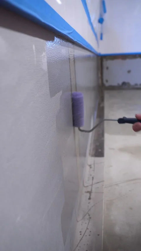 Close up of roller spreading wet coating on wall 스톡 동영상 325539234