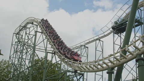 Close up of rollercoaster driving down and going through a vertical loop in Video stock 337745591