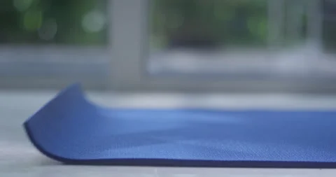 Close up of rolling out Blue Yoga or Exercise Mat with hand Stock Footage 172109216
