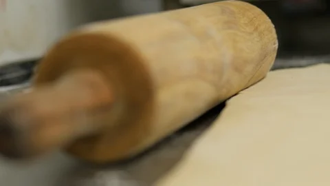 Close up of rolling pin next to flat dough Stock Footage 93371320