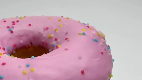 Close up rolling strawberry donut isolated on white background Stock Footage 157677177