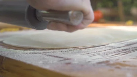 Close up rolling thin dough for fresh pasta at wooden table. Chef cook rolling Stock Footage 108315893