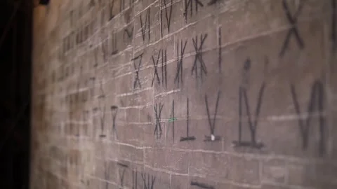 Close-up of Roman numerals on an old gray wall in a dark room. Quest. Stock Footage 310656050