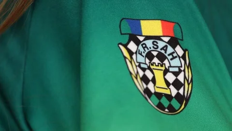 Close Up of the Romanian Chess Federation Logo on a child's T-shirt Sleeve Stock Footage 290026347