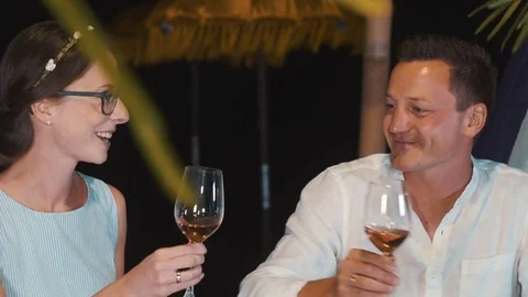 Close up of romantic couple clinking glasses at outdoors tropical dinner Video stock 81645464