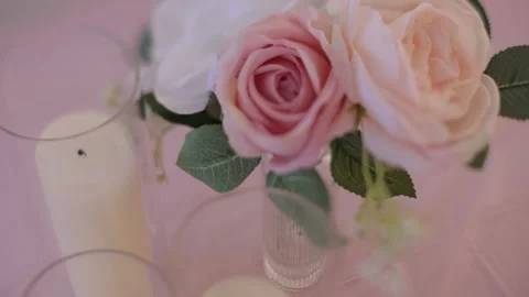 Close-up of a romantic flower arrangement featuring pink roses and candles.mp4 Stock Footage 316301662