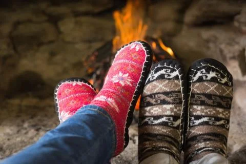 Close up of romantic legs in socks in front of fireplace Stock Photos
