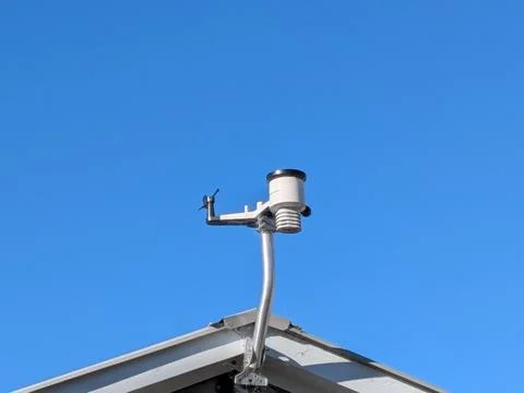 Close-up rooftop weather sensor system beneath clear sky, Stock-Fotos